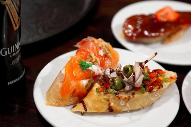 Qui connaît un bar à vin avec une atmosphère intimiste et qui propose des tapas améliorés ?